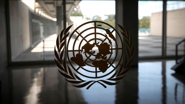 The United Nations logo is seen on a window in an empty hallway at United Nations headquarters during the 75th annual U.N. General Assembly high-level debate, which is being held mostly virtually due to the coronavirus disease (COVID-19) pandemic in New York, U.S., September 21, 2020 - Sputnik International