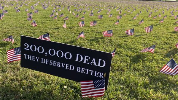 A sign near the Washington Monument reads, 200,000 dead. They deserved better. Each flag in the installation represents 10 Americans who died of COVID-19. - Sputnik International