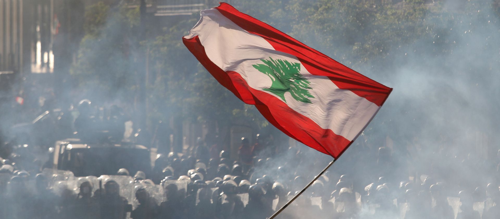 A demonstrator waves the Lebanese flag in front of riot police A demonstrator waves the Lebanese flag in front of riot police - Sputnik International, 1920, 30.09.2020