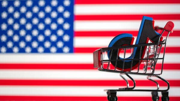 A shopping cart carrying a 3D printed TikTok logo is seen in front of displayed US flag - Sputnik International