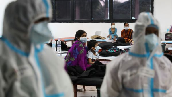 A woman sits with her child inside a quarantine centre for the coronavirus disease (COVID-19) patients amidst the spread of the disease at an indoor sports complex in New Delhi, India, September 22, 2020 - Sputnik International
