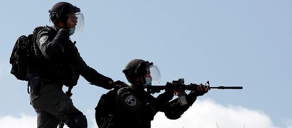 An Israeli border policeman points his weapon towards Palestinian demonstrators during a protest against Jewish settlements, in Asira al-Qibliya in the Israeli-occupied West Bank September 25, 2020. An Israeli border policeman points his weapon towards Palestinian demonstrators during a protest against Jewish settlements, in Asira al-Qibliya in the Israeli-occupied West Bank September 25, 2020. - Sputnik International