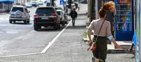 A young woman runs down a street in Stepanakert A young woman runs down a street in Stepanakert - Sputnik International