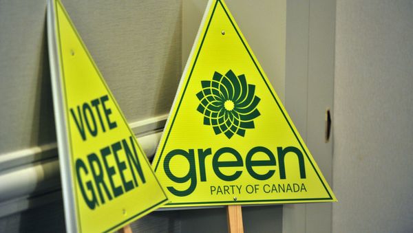 Green Pary signs are seen as Elizabeth May (out of frame), leader of the Green Party of Canada, addresses a press conference in Vancouver BC, March 30, 2011, to comment on being barred from the election leaders debate by TV companies. - Sputnik International