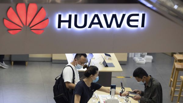 In this July 15, 2020, file photo, visitors wearing masks to curb the spread of the coronavirus look at the latest products at a Huawei store in Beijing. China accused Washington of damaging global trade with sanctions that threaten to cripple tech giant Huawei and said Tuesday it will protect Chinese companies but gave no indication of possible retaliation - Sputnik International
