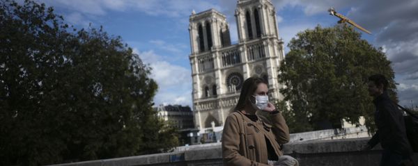 A woman walks by Notre Dame cathedral Saturday Sept.26, 2020 in Paris. While France suffered testing shortages early in the pandemic, ramped-up testing since this summer has helped authorities track a rising tide of infections across the country. - Sputnik International