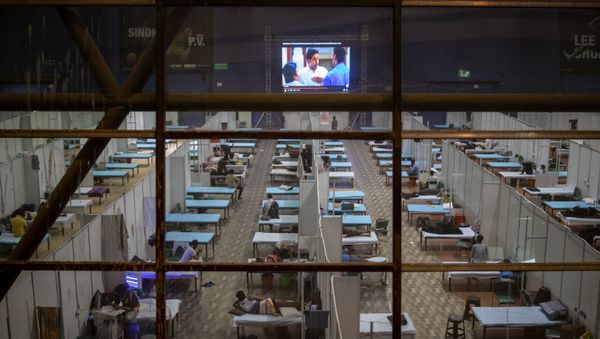 Patients watch a movie on a big screen at a makeshift COVID-19 care center set up in an indoor sports stadium, in New Delhi, India, Saturday, Sept. 19, 2020 - Sputnik International