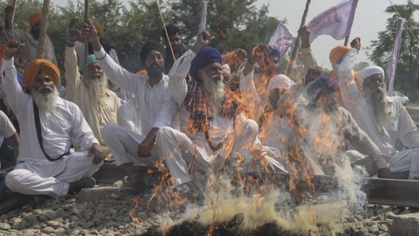 Farmers shout slogans while burning an effigy with pictures of Congress party leader Rahul Gandhi, Indian Prime Minister Narendra Modi, Aam Aadmi Party (AAP) and Member of Parliament Bhagwant Mann and Shiromani Akali Dal (SAD) party President Sukhbir Singh Badal during a protest against the recent passing of agriculture reform bills in the Parliament, on the outskirts of Amritsar on October 6, 2020 - Sputnik International
