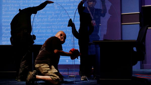 Commission on Presidential Debates staff clean the freshly installed protective plexiglass panels put in place as a coronavirus disease precaution between the candidates' seats for the 2020 vice presidential debate between Vice President Mike Pence and Democratic vice presidential nominee and U.S. Senator Kamala Harris on the campus of the University of Utah in Salt Lake City, Utah, U.S., October 6, 2020 Commission on Presidential Debates staff clean the freshly installed protective plexiglass panels put in place as a coronavirus disease precaution between the candidates' seats for the 2020 vice presidential debate between Vice President Mike Pence and Democratic vice presidential nominee and U.S. Senator Kamala Harris on the campus of the University of Utah in Salt Lake City, Utah, U.S., October 6, 2020 - Sputnik International