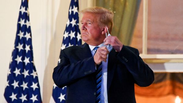 U.S. President Donald Trump pulls off his face mask as he returns to the White House after being hospitalized at Walter Reed Medical Center for coronavirus disease (COVID-19), in Washington - Sputnik International