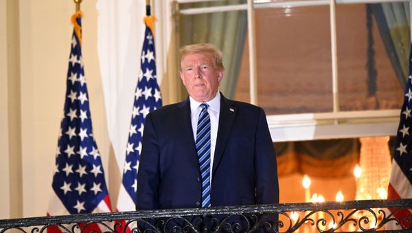 U.S. President Donald Trump poses atop the Truman Balcony of the White House after taking off his protective face mask as he returns to the White House after being hospitalized at Walter Reed Medical Center for coronavirus disease (COVID-19) treatment, in Washington, U.S. October 5, 2020. - Sputnik International