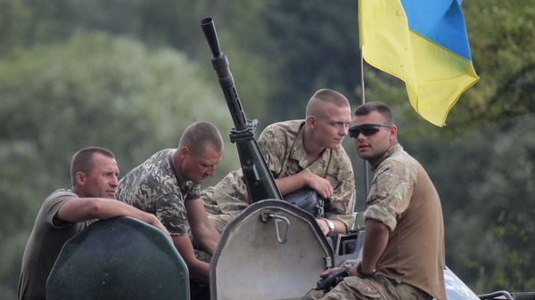 Ukrainian soldiers atop an APC watch training exercises under the supervision of British instructors on the military base outside Zhitomir, Ukraine, Tuesday, Aug. 11, 2015 - Sputnik International