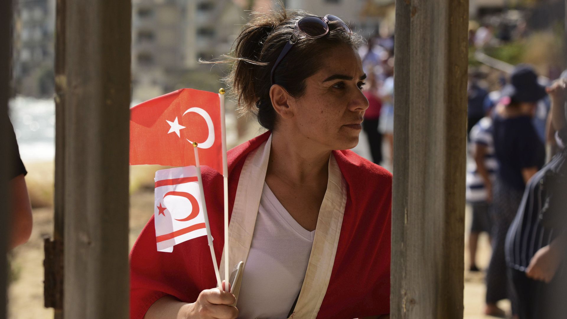 A woman with Turkish and Turkish Cypriot breakaway flags walks along at the beach with abandoned hotels after police open the beachfront of Varosha, an uninhabited, fenced-off suburb in war-divided Cyprus' in the Turkish occupied area in the breakaway Turkish Cypriot north on Thursday, Oct. 8, 2020.  - Sputnik International, 1920, 27.09.2021