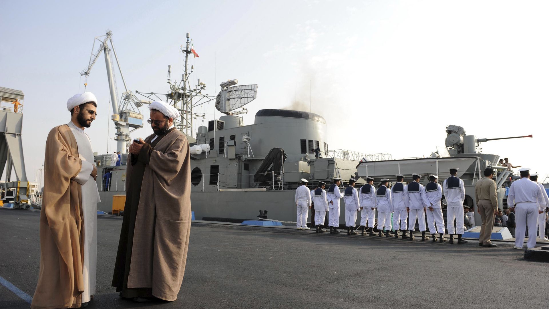 In this Feb. 21, 2010 photo, two clerics stand at left as Iran's Jamaran guided-missile destroyer and navy members prepare for an exercise in the Persian Gulf, along the coast of Iran.  - Sputnik International, 1920, 03.05.2021