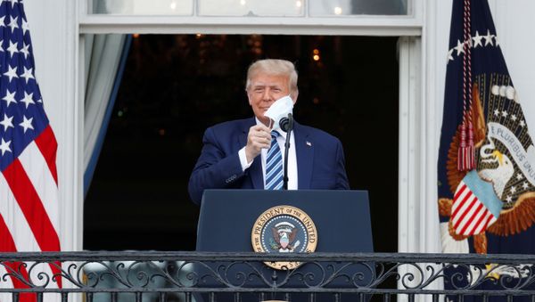 U.S. President Donald Trump takes off his face mask as he comes out on a White House balcony to speak to supporters gathered on the South Lawn for a campaign rally that the White House is calling a peaceful protest in Washington, U.S., October 10, 2020. REUTERS/Tom Brenner - Sputnik International