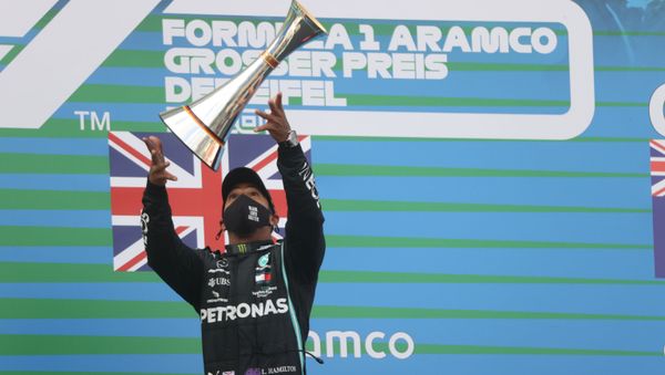 Winner Mercedes' British driver Lewis Hamilton celebrates winning with the trophy on the podium after the German Formula One Eifel Grand Prix at the Nuerburgring circuit in Nuerburg, western Germany, on October 11, 2020. - Sputnik International