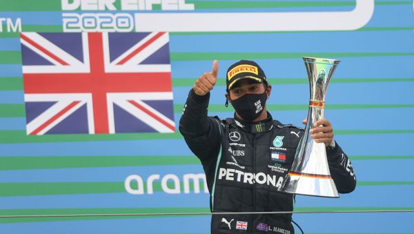 Winner Mercedes' British driver Lewis Hamilton celebrates winning with the trophy on the podium after the German Formula One Eifel Grand Prix at the Nuerburgring circuit in Nuerburg, western Germany, on October 11, 2020. - Sputnik International
