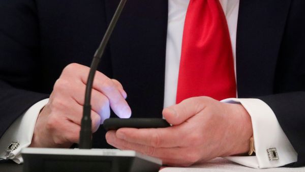 U.S. President Donald Trump taps the screen on a mobile phone at the approximate time a tweet was released from his Twitter account, during a roundtable discussion on the reopening of small businesses in the State Dining Room at the White House in Washington, U.S., June 18, 2020 - Sputnik International