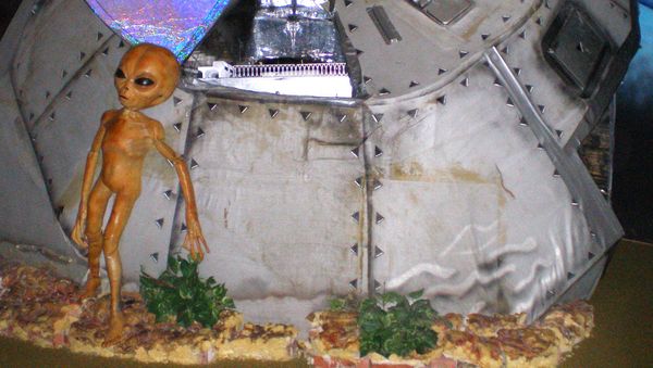 This photo taken in December 2006 at the Area 51 exhibit at the Alien Zone in Roswell, N.M., shows a model alien standing outside a crashed spaceship.  - Sputnik International