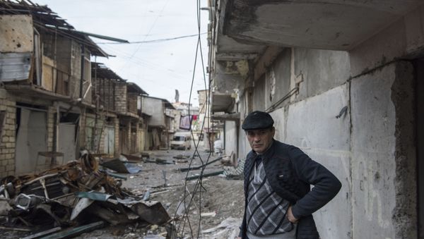 A man stands near a house with a row of destroyed barns in the background in Stepanakert, a self-proclaimed Republic of the Nagorno-Karabakh. A man stands near a house with a row of destroyed barns in the background in Stepanakert, a self-proclaimed Republic of the Nagorno-Karabakh. - Sputnik International