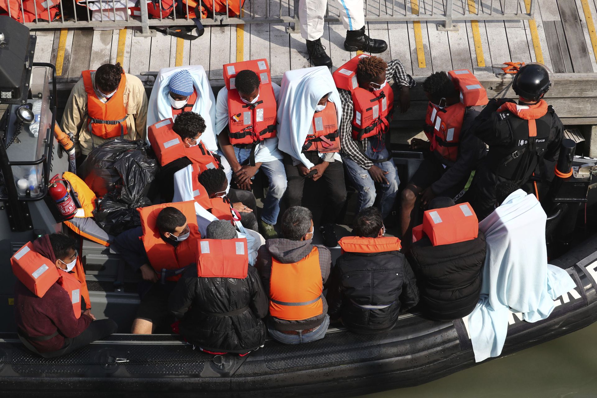 A group of people, thought to be migrants wait on a Border Force rib to come ashore at Dover marina in Kent, England after a small boat incident in the English Channel, Tuesday Sept. 22, 2020.  - Sputnik International, 1920, 22.11.2021