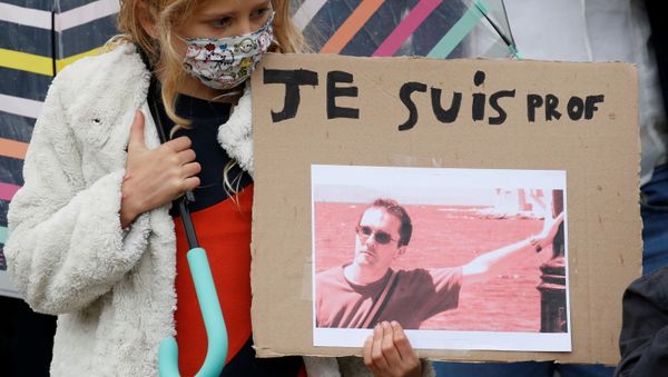 A girl holds a banner with a picture of Samuel Paty, the French teacher who was beheaded on the streets of the Paris suburb of Conflans St Honorine, during a tribute at the Place de la Republique, in Lille, France, October 18, 2020. REUTERS/Pascal Rossignol NO RESALES. NO ARCHIVES. A girl holds a banner with a picture of Samuel Paty, the French teacher who was beheaded on the streets of the Paris suburb of Conflans St Honorine, during a tribute at the Place de la Republique, in Lille, France, October 18, 2020. REUTERS/Pascal Rossignol NO RESALES. NO ARCHIVES. - Sputnik International