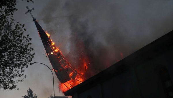 The spire of a church set on fire topples during a protest against Chile's government, on the one-year anniversary of the protests and riots that rocked the capital in 2019, in Santiago, Chile, October 18, 2020. - Sputnik International