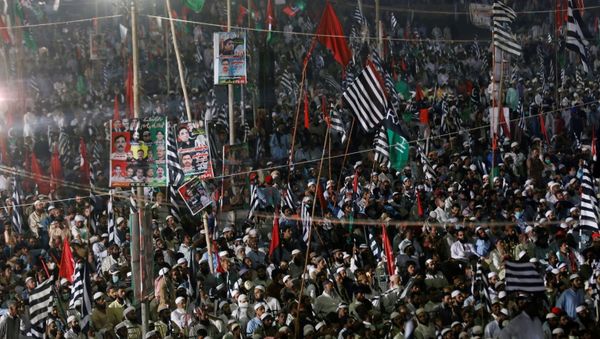 Supporters of Pakistan Democratic Movement (PDM), an alliance of political opposition parties, wave flags as they listen to their leaders during an anti-government protest rally in Karachi, Pakistan October 18, 2020 - Sputnik International