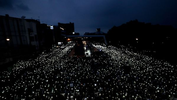 Pro-democracy activists wave mobile phones with lights during a demonstration at Kaset intersection, suburbs of Bangkok, Thailand, Monday, Oct. 19, 2020. Thai authorities worked Monday to stem a growing tide of protests calling for the prime minister to resign by threatening to censor news coverage, raiding a publishing house and attempting to block the Telegram messaging app used by demonstrators. - Sputnik International