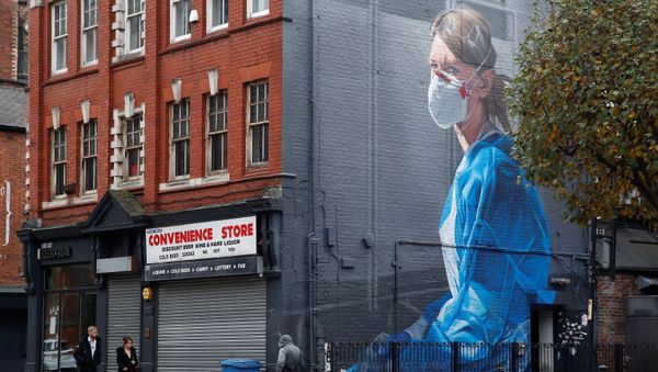 People walk past a mural, as the coronavirus disease (COVID-19) outbreak continues, in Manchester, Britain October 19, 2020 - Sputnik International
