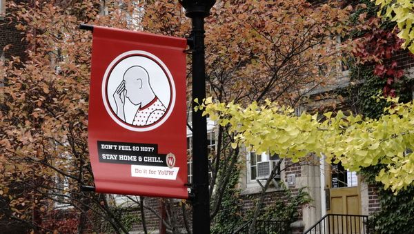 A sign encouraging University of Wisconsin-Madison students with COVID-19 symptoms to self-quarantine is pictured as the coronavirus disease (COVID-19) outbreak continues in Madison, Wisconsin, 19 October 2020 A sign encouraging University of Wisconsin-Madison students with COVID-19 symptoms to self-quarantine is pictured as the coronavirus disease (COVID-19) outbreak continues in Madison, Wisconsin, 19 October 2020 - Sputnik International
