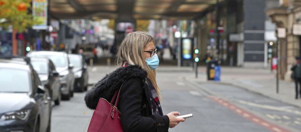 A woman wearing a face mask walks in Manchester, England, Monday, 19 October 2020 A woman wearing a face mask walks in Manchester, England, Monday, 19 October 2020 - Sputnik International