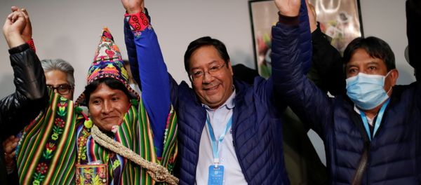 Presidential candidate Luis Arce of the Movement to Socialism party (MAS) reacts next to vice presidential candidate David Choquehuanca, who wears a protective face mask, after addressing the media during the presidential election in La Paz, Bolivia, October 19, 2020 Presidential candidate Luis Arce of the Movement to Socialism party (MAS) reacts next to vice presidential candidate David Choquehuanca, who wears a protective face mask, after addressing the media during the presidential election in La Paz, Bolivia, October 19, 2020 - Sputnik International