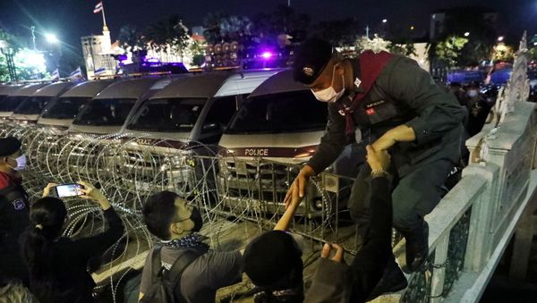 Demonstrators help a police officer outside the Government House during an anti-government protest in Bangkok, Thailand October 21, 2020. - Sputnik International