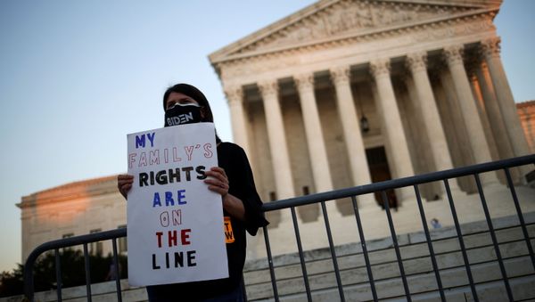 A person wearing a protective face mask reading Biden holds a placard in front of the U.S Supreme Court building, in Washington D.C., U.S., October 21, 2020.  - Sputnik International