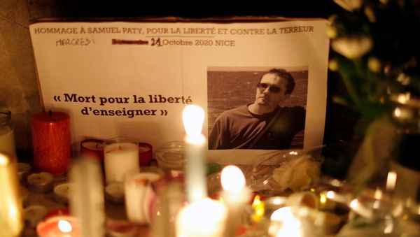 Candles are lit at a makeshift memorial as people gather to pay homage to Samuel Paty, the French teacher who was beheaded on the streets of the Paris suburb of Conflans-Sainte-Honorine, as part of a national tribute, in Nice, France, October 21, 2020 - Sputnik International