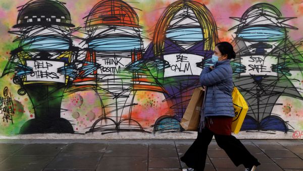 A woman wearing a face mask walks past graffiti, amid the coronavirus disease (COVID-19) outbreak, in central London Britain October 15, 2020 A woman wearing a face mask walks past graffiti, amid the coronavirus disease (COVID-19) outbreak, in central London Britain October 15, 2020 - Sputnik International