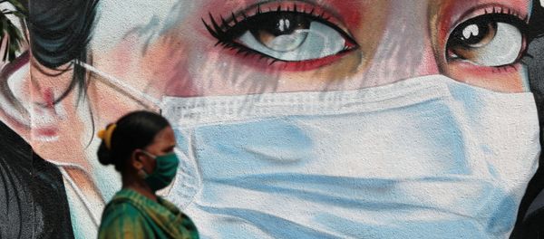 A woman walks past a graffiti of a girl wearing a protective mask amidst the spread of the coronavirus disease (COVID-19) in Mumbai, India, October 23, 2020 A woman walks past a graffiti of a girl wearing a protective mask amidst the spread of the coronavirus disease (COVID-19) in Mumbai, India, October 23, 2020 - Sputnik International