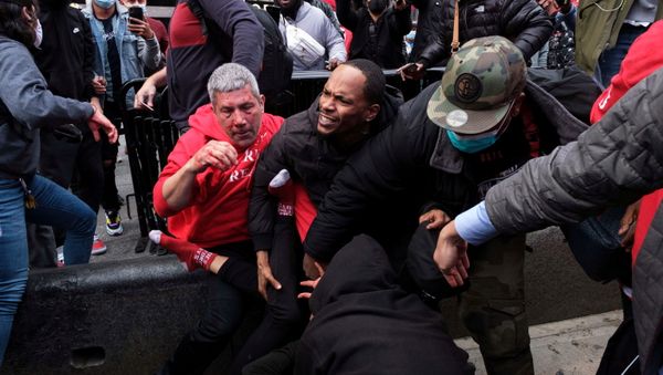A man protects a supporter of U.S. President Donald Trump from anti-Trump protesters after clashes in the Manhattan borough of New York City, U.S. October 25, 2020. - Sputnik International