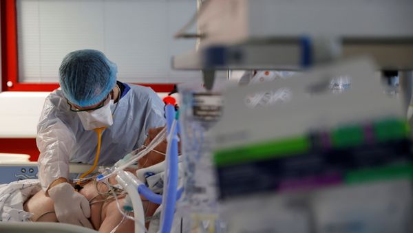 A doctor, wearing a protective mask and a protective suit, works in an Intensive Care Unit (ICU) where patients suffering from the coronavirus disease (COVID-19) are treated at the Bethune-Beuvry hospital in Beuvry, France, October 16, 2020.  - Sputnik International