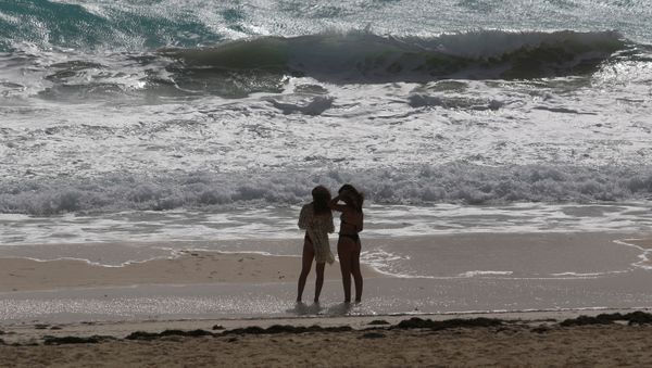 Tourists stand at a beach as Hurricane Zeta approaches, in Cancun, Mexico October 26, 2020. - Sputnik International