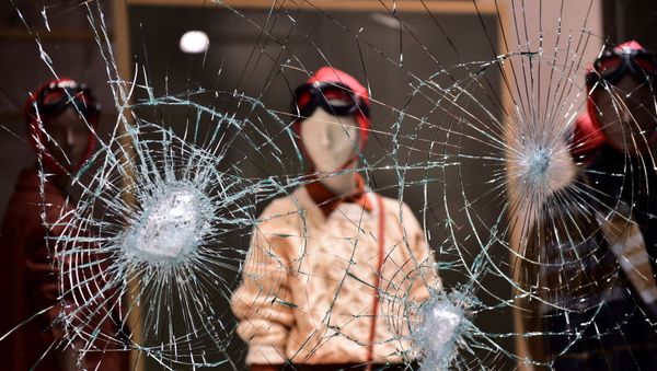 A damaged window of a store is seen as people protest against the new restrictions introduced by the government to curb the coronavirus disease (COVID-19) infections, in Turin, Italy, October 26, 2020. - Sputnik International