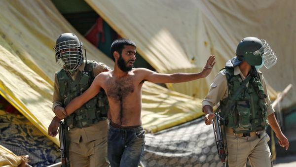 A man gestures after he was detained by Indian policemen during a protest near the site of a gun battle between Indian security forces and suspected militants, in Srinagar, 12 October 2020. - Sputnik International
