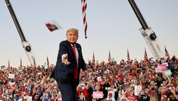 U.S. President Donald Trump throws a face mask from the stage during a campaign rally, his first since being treated for the coronavirus disease (COVID-19), at Orlando Sanford International Airport in Sanford, Florida, U.S., October 12, 2020 - Sputnik International