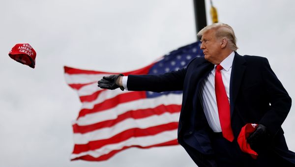 U.S. President Donald Trump tosses out Make America Great Again (MAGA) caps as he arrives for a campaign rally at Oakland County International Airport in Waterford Township, Michigan, U.S., October 30, 2020. REUTERS/Carlos Barria U.S. President Donald Trump tosses out Make America Great Again (MAGA) caps as he arrives for a campaign rally at Oakland County International Airport in Waterford Township, Michigan, U.S., October 30, 2020. REUTERS/Carlos Barria - Sputnik International