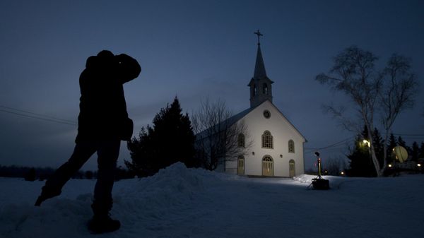 A journalist takes a photo of the church in La Motte, Quebec, at twilight Wednesday, 13 March 2013, in La Motte. THE CANADIAN PRESS/Adrian Wyld - Sputnik International