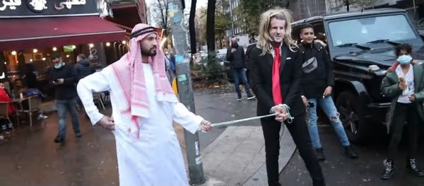 German YouTuber of Syrian origin, Fayez Kanfash, drags another person dressed as French President Emmanuel Macron through the streets of Berlin German YouTuber of Syrian origin, Fayez Kanfash, drags another person dressed as French President Emmanuel Macron through the streets of Berlin - Sputnik International