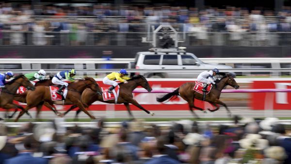 In this Nov. 7, 2017, file photo, horse race past the crowd during race 1 before the running of the Melbourne Cup at Flemington Racecourse in Melbourne. In Australia, where horse racing is arguably more popular than in any other country on the planet, the sport is continuing, minus the spectators, despite the nation's struggle to contain the new coronavirus.  - Sputnik International
