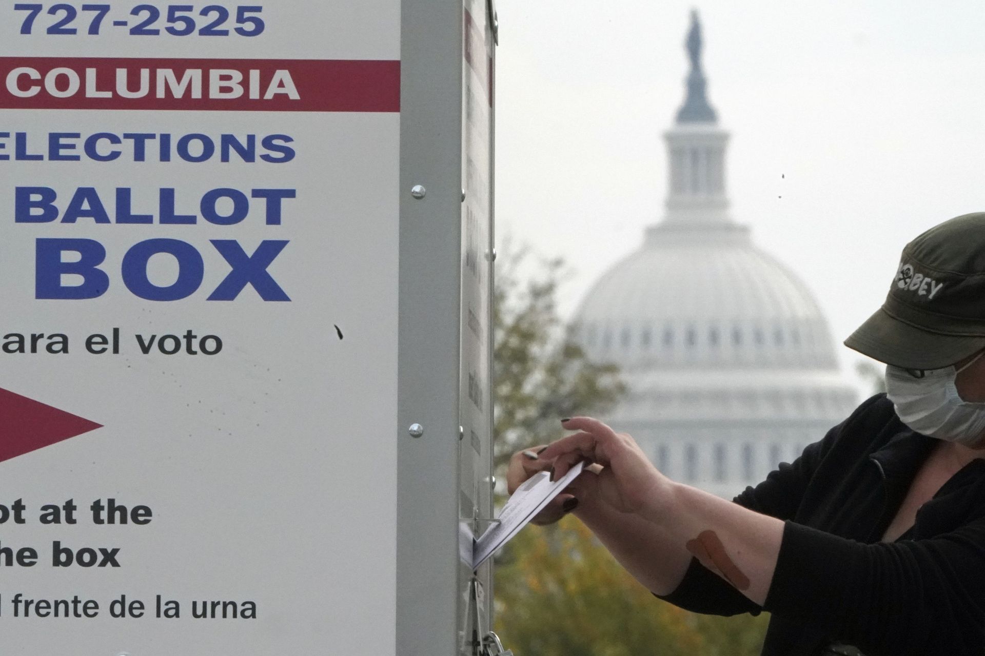 With the U.S. Capitol dome visible, a voter drops a ballot into an early voting drop box, Wednesday, Oct. 28, 2020, at Union Market in Washington With the U.S. Capitol dome visible, a voter drops a ballot into an early voting drop box, Wednesday, Oct. 28, 2020, at Union Market in Washington - Sputnik International, 1920, 07.09.2021