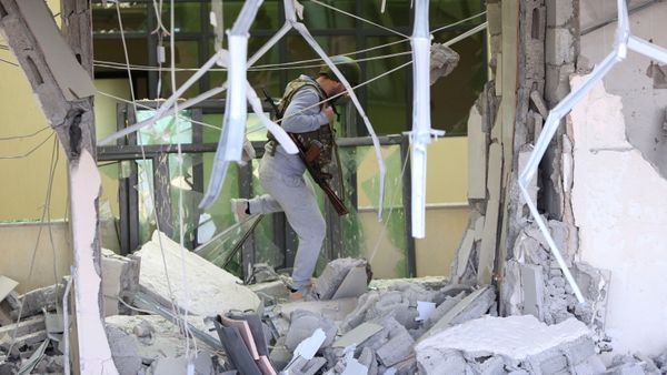 An armed man walks inside a damaged medical centre following recent shelling in Stepanakert, in the course of a military conflict over the breakaway region of Nagorno-Karabakh, October 28, 2020.  - Sputnik International